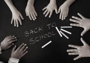 children's hands around text back to school